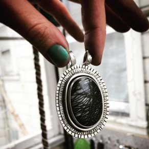 necklace pendant held by fingers