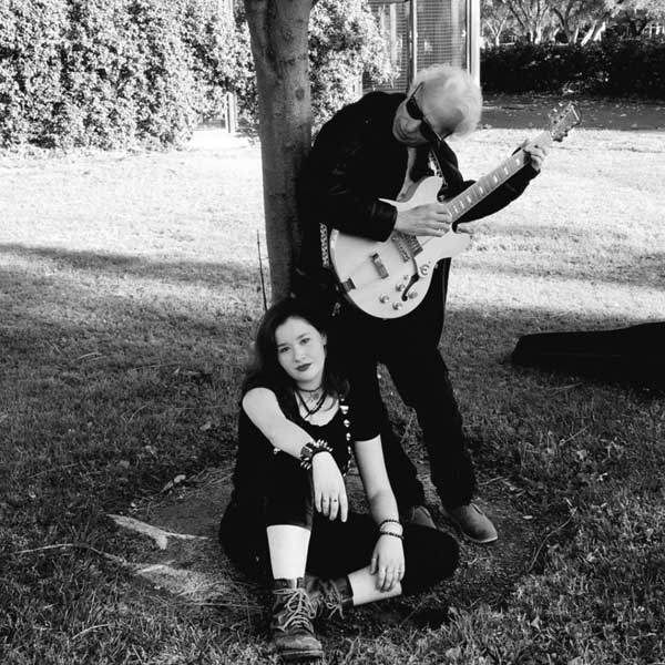 Vita Rhie Quintanilla and Anthony Tadlock playing music in a park