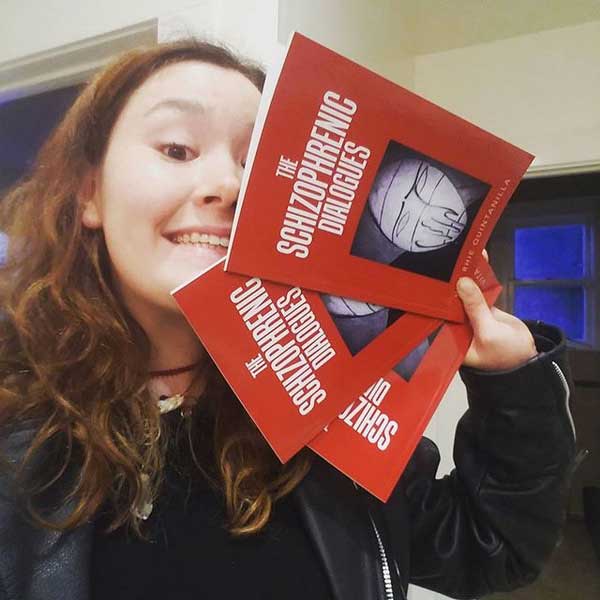 Vita Rhie Quintanilla with hard copies of The Schizophrenic Dialogues