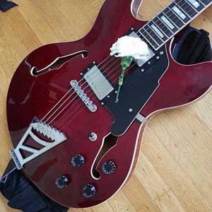 deep red electric guitar with white carnation